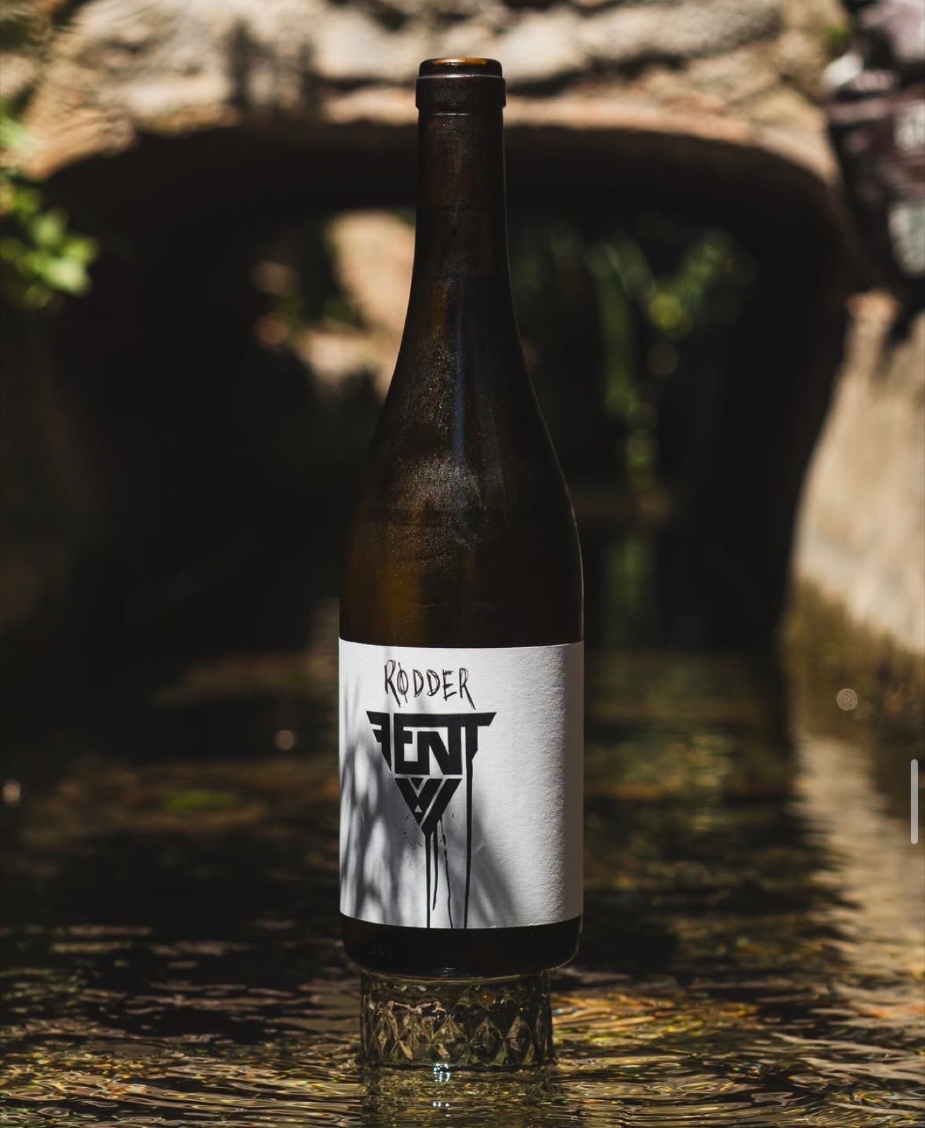 Una copa de vino sobre la mesa de la terraza del Bar Molino, junto a la acequia.