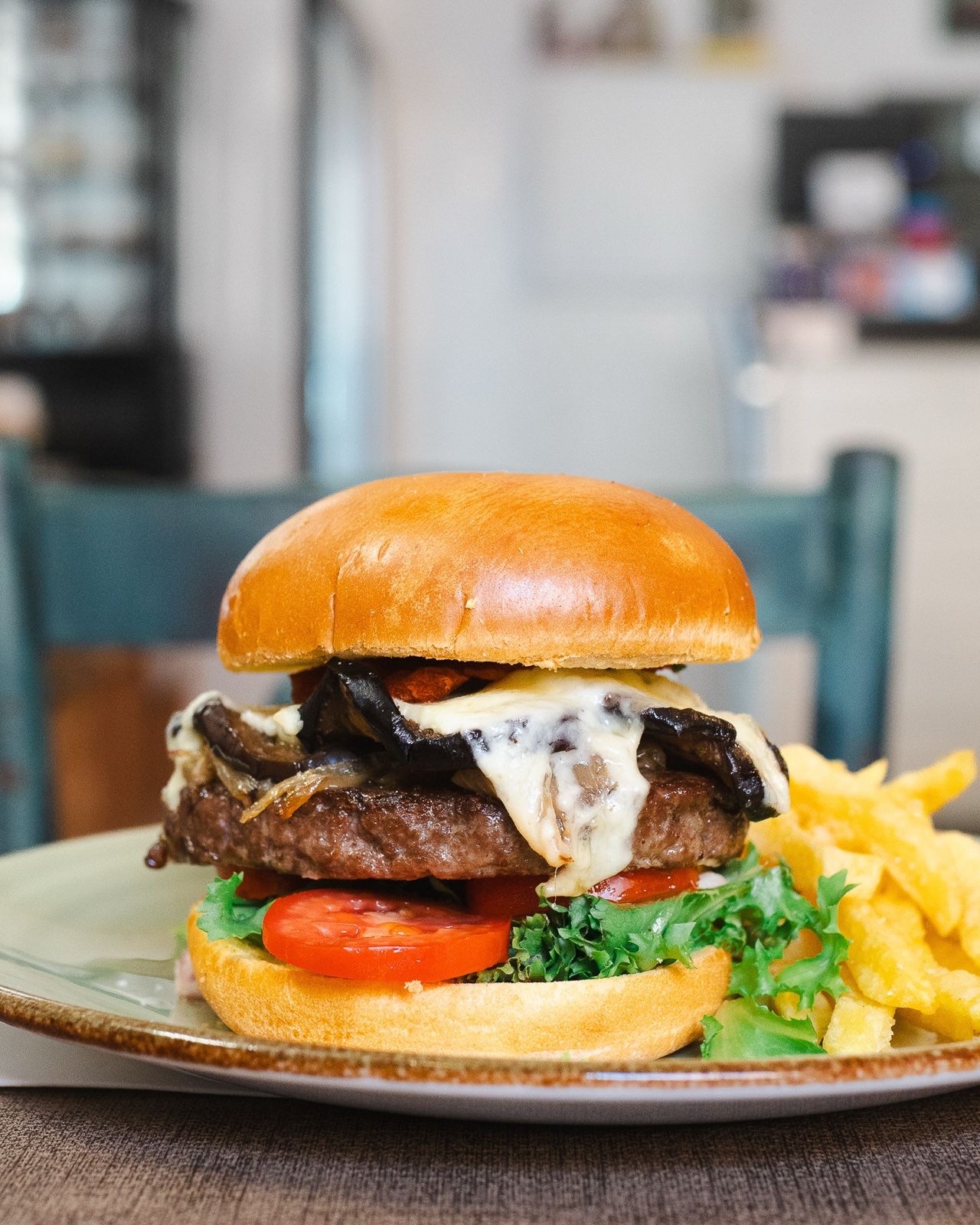 Molino-Burger mit Fleisch, geschmolzenem Käse und Pilzen, mit Pommes