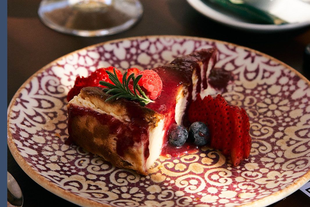 Tarta de almendra con glaseado de fresas, junto a una copa de hierbas de la Tramuntana y un café, postre del Bar Molino, Sóller