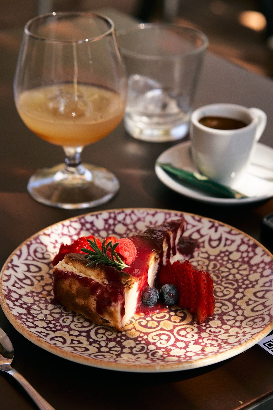 Tarta de almendra con glaseado de fresas, junto a una copa de hierbas de la Tramuntana y un café, postre del Bar Molino, Sóller