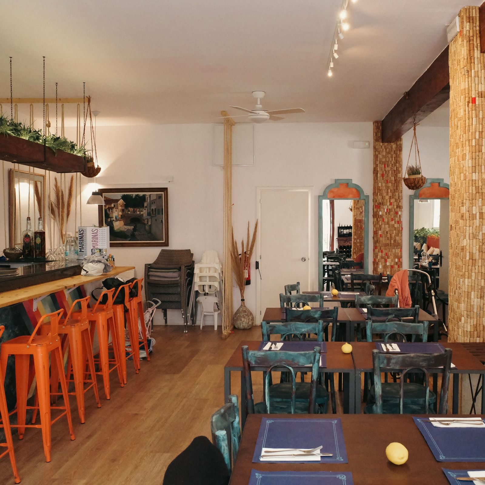 Essbereich des Bar Molino mit orangefarbenen Barhockern und türkisen Tischen