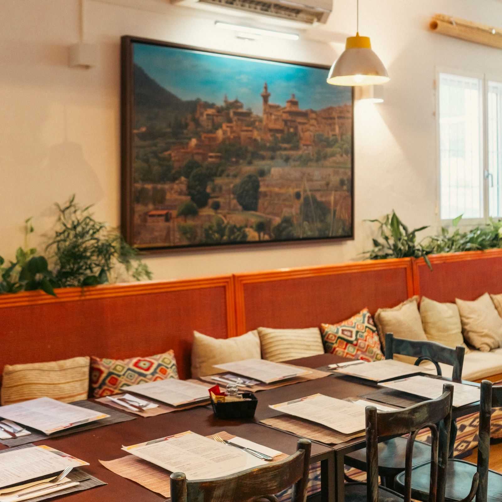 Innenraum des Bar Molino mit Sofas und einem Gemälde eines mallorquinischen Dorfes