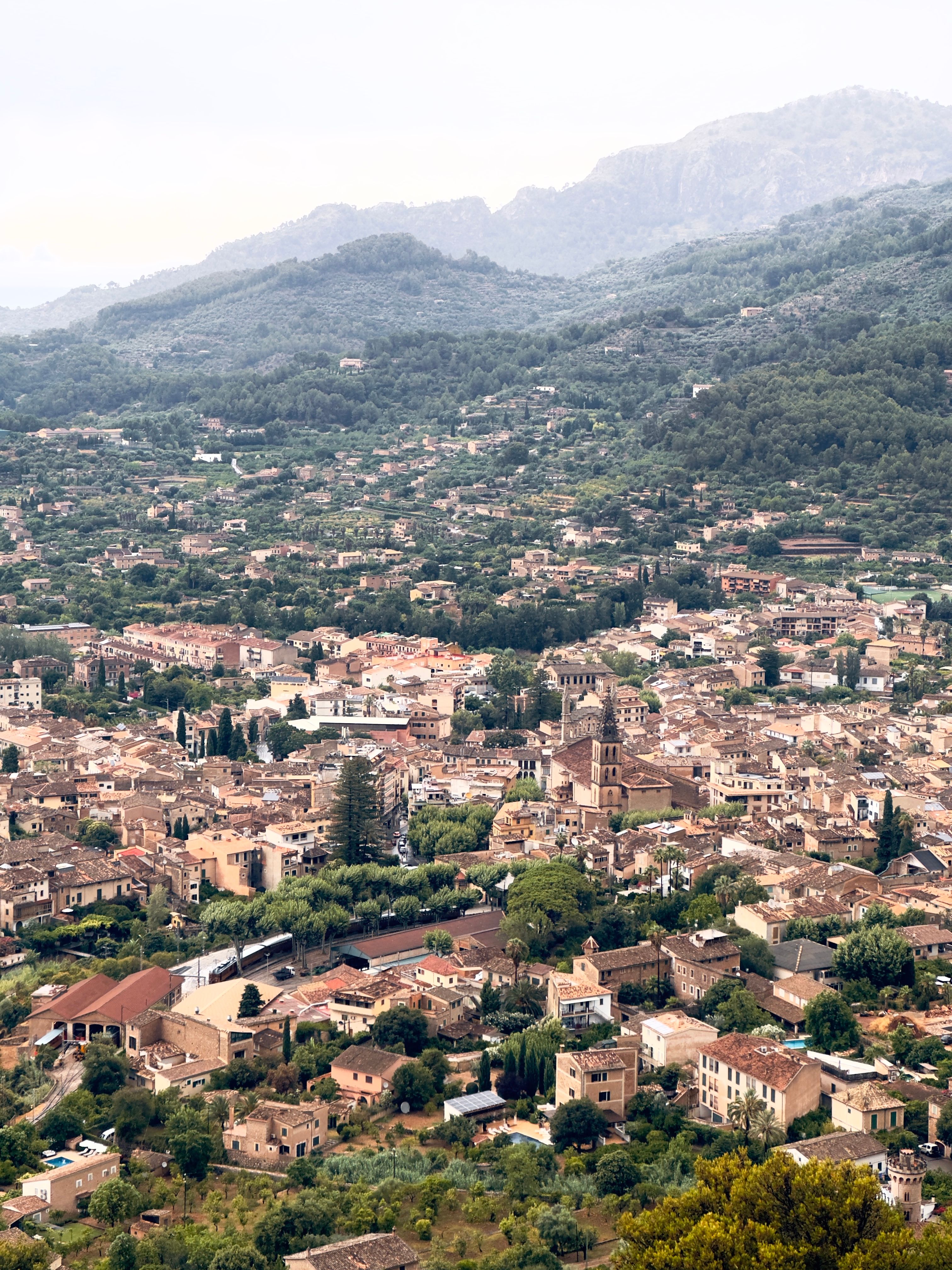 Vista aérea del valle de Sóller con el pueblo, la torre de Sant Bartomeu y las montañas de la Tramuntana