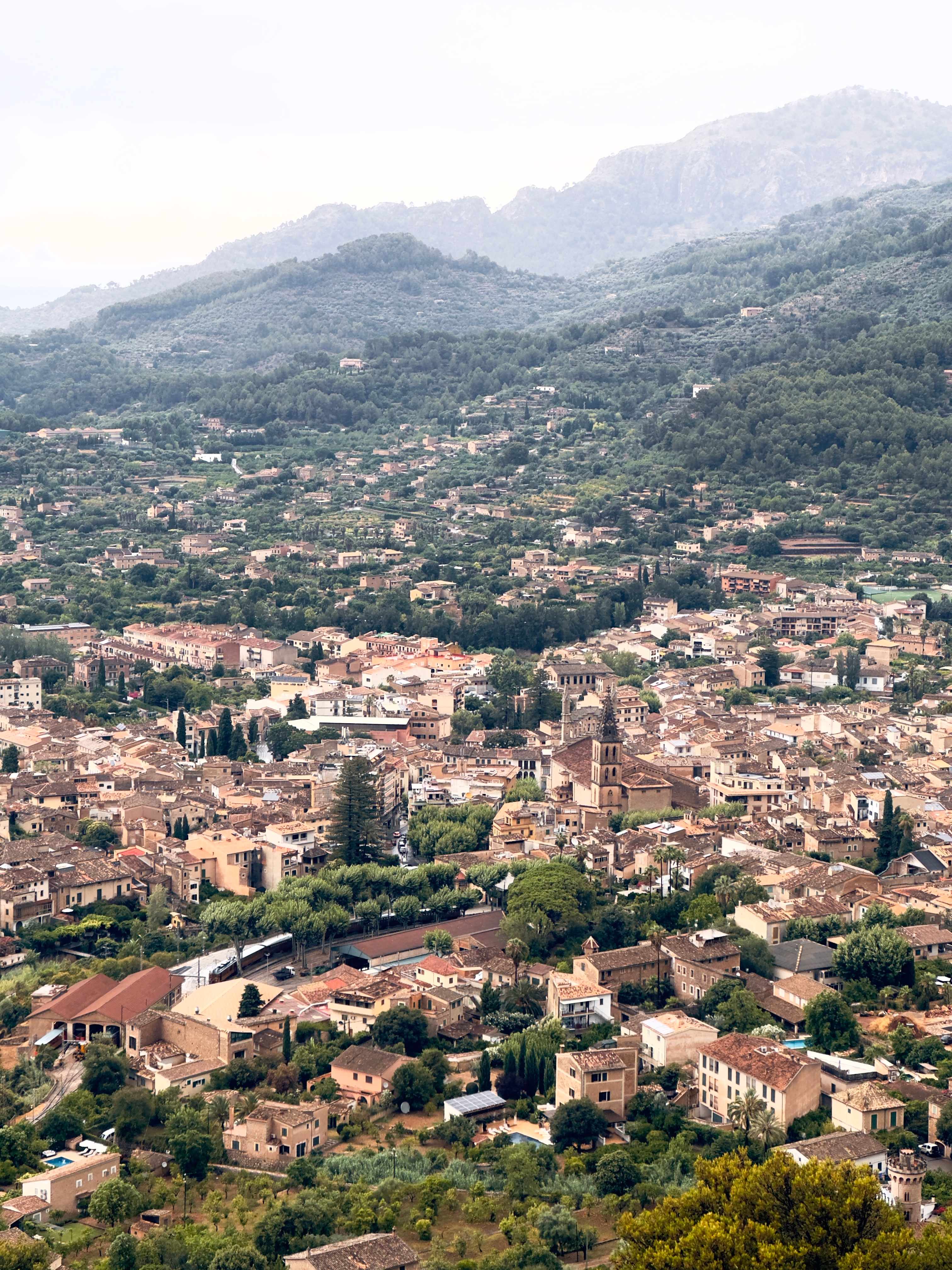 Vista aérea del valle de Sóller con el pueblo, la torre de Sant Bartomeu y las montañas de la Tramuntana
